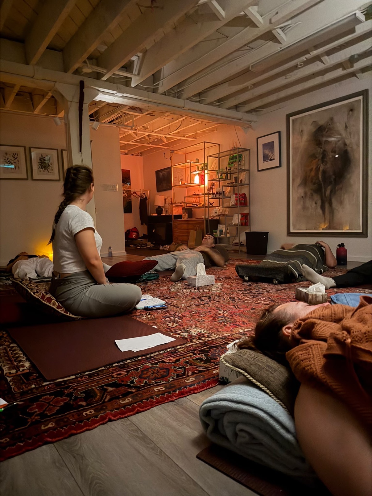 A group lying on mats during a guided session in a warm studio